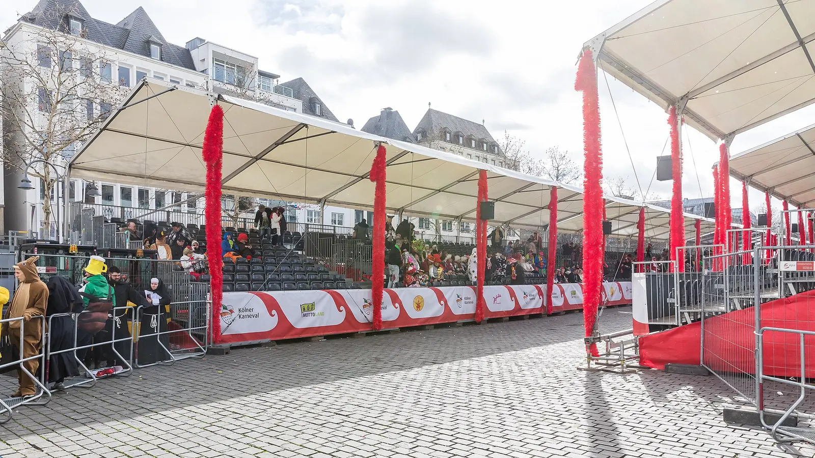 Covered grandstands and spectators on the Heumarkt in Cologne during the carnival street celebrations
