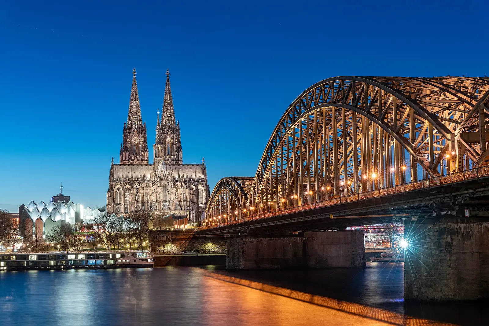 Cologne Cathedral and the Hohenzollern Bridge across the Rhine at blue hour