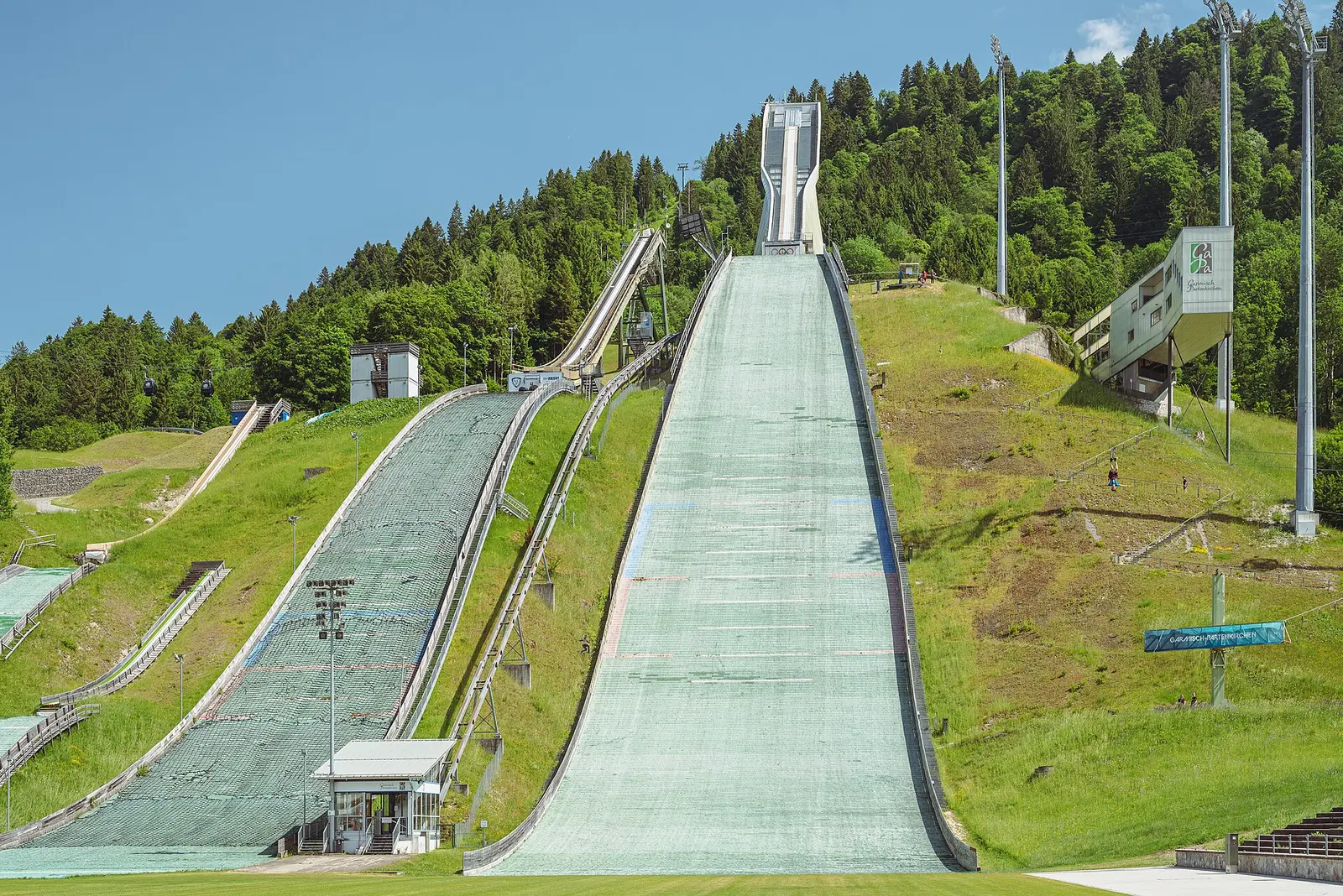 The Olympic ski jump hill at Garmisch-Partenkirchen with its inrun and landing slope below forested hills