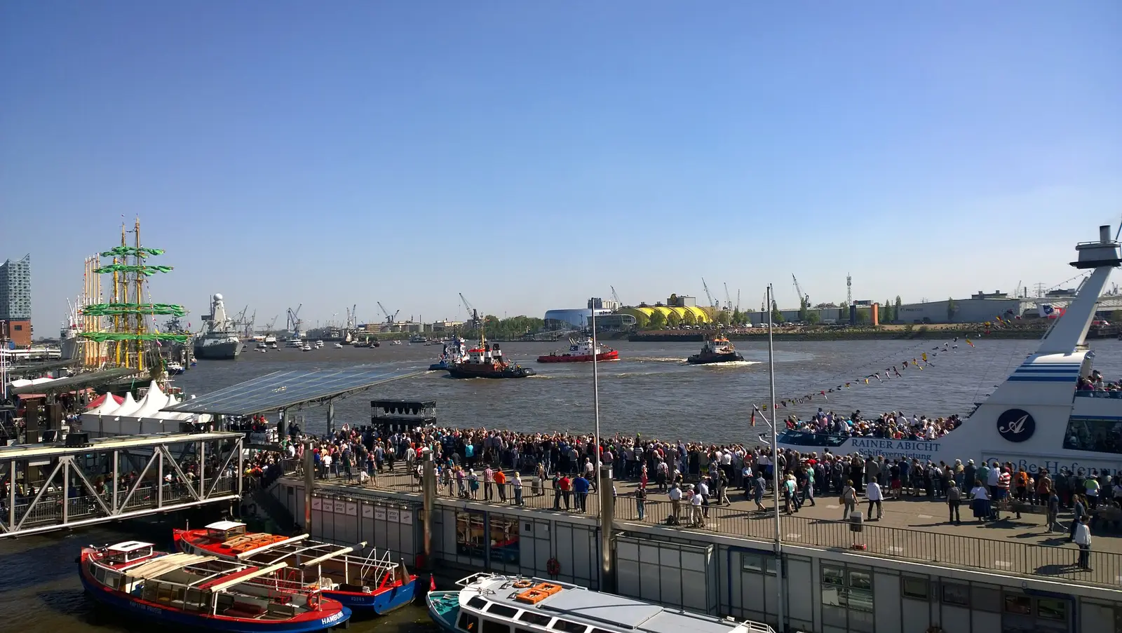 Spectators lining the Hamburg quay as tugboats perform their harbour ballet during the Harbour Birthday