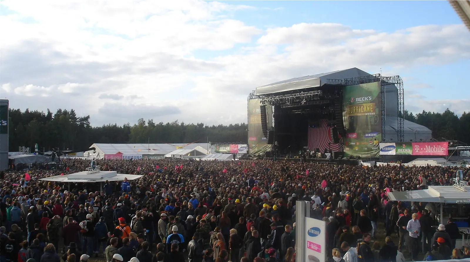A large festival crowd in front of the main stage at the Hurricane Festival under a cloudy sky