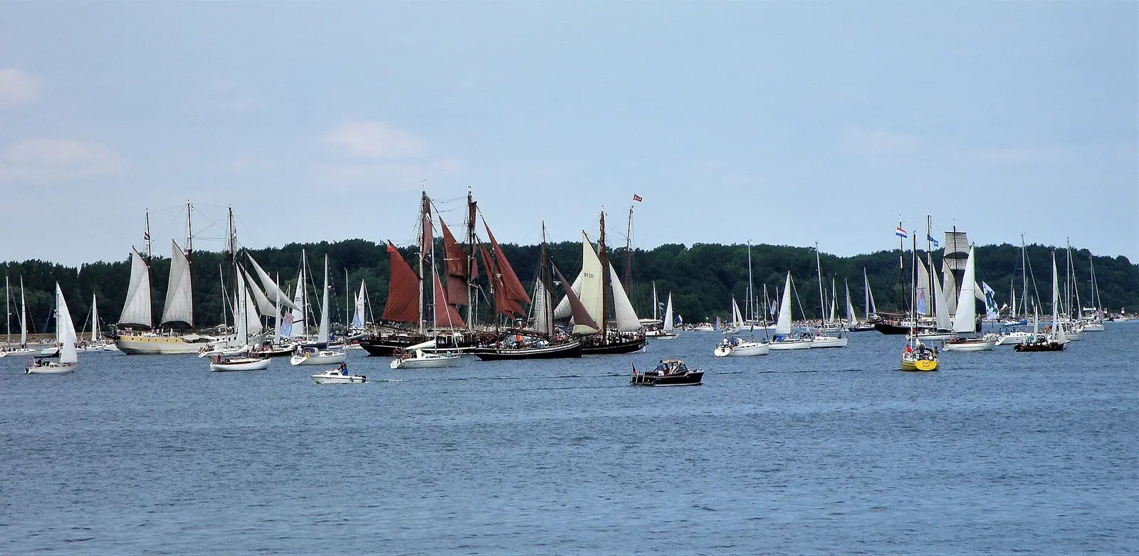 Traditional sailing ships and sailboats crowd the Kiel Fjord during the Windjammer Parade of Kiel Week