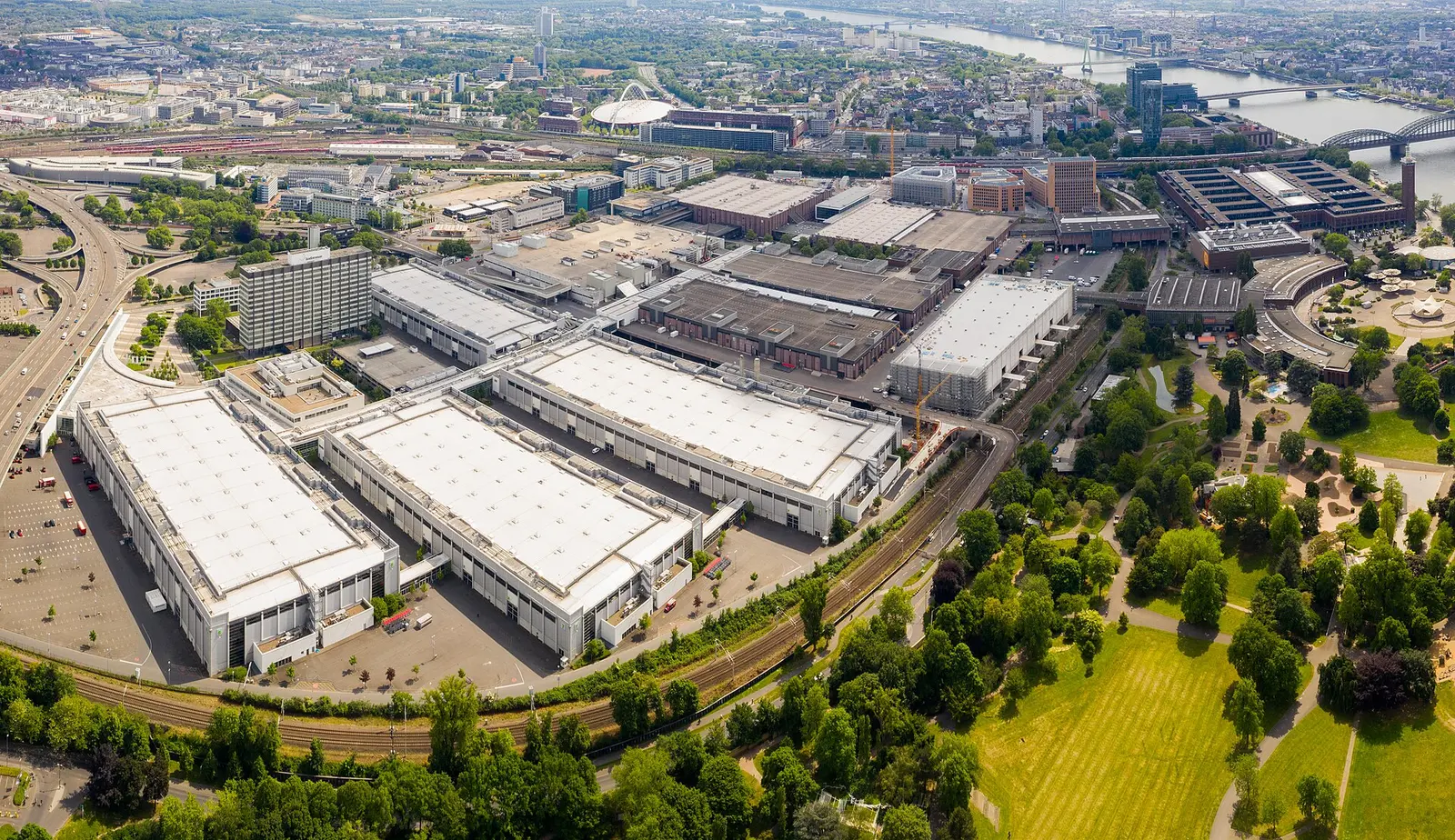Aerial view of the Koelnmesse exhibition halls in Cologne with the Rhine and parkland beside them